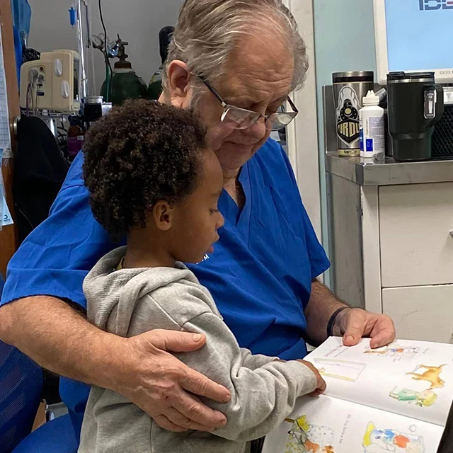 Dr. Gormley sharing a book with a child at Highland.
