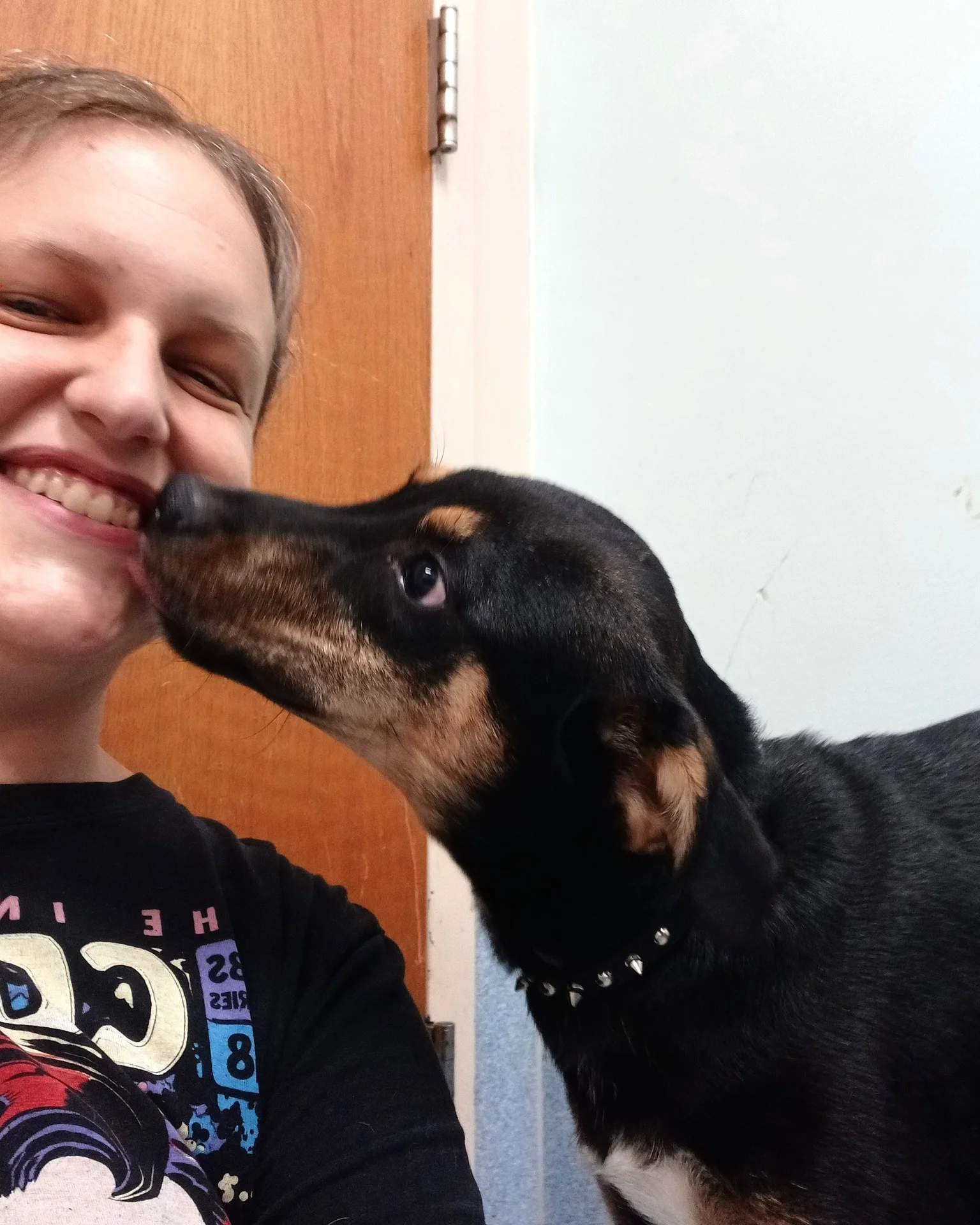 An affectionate dog greeting a smiling Highland team member.